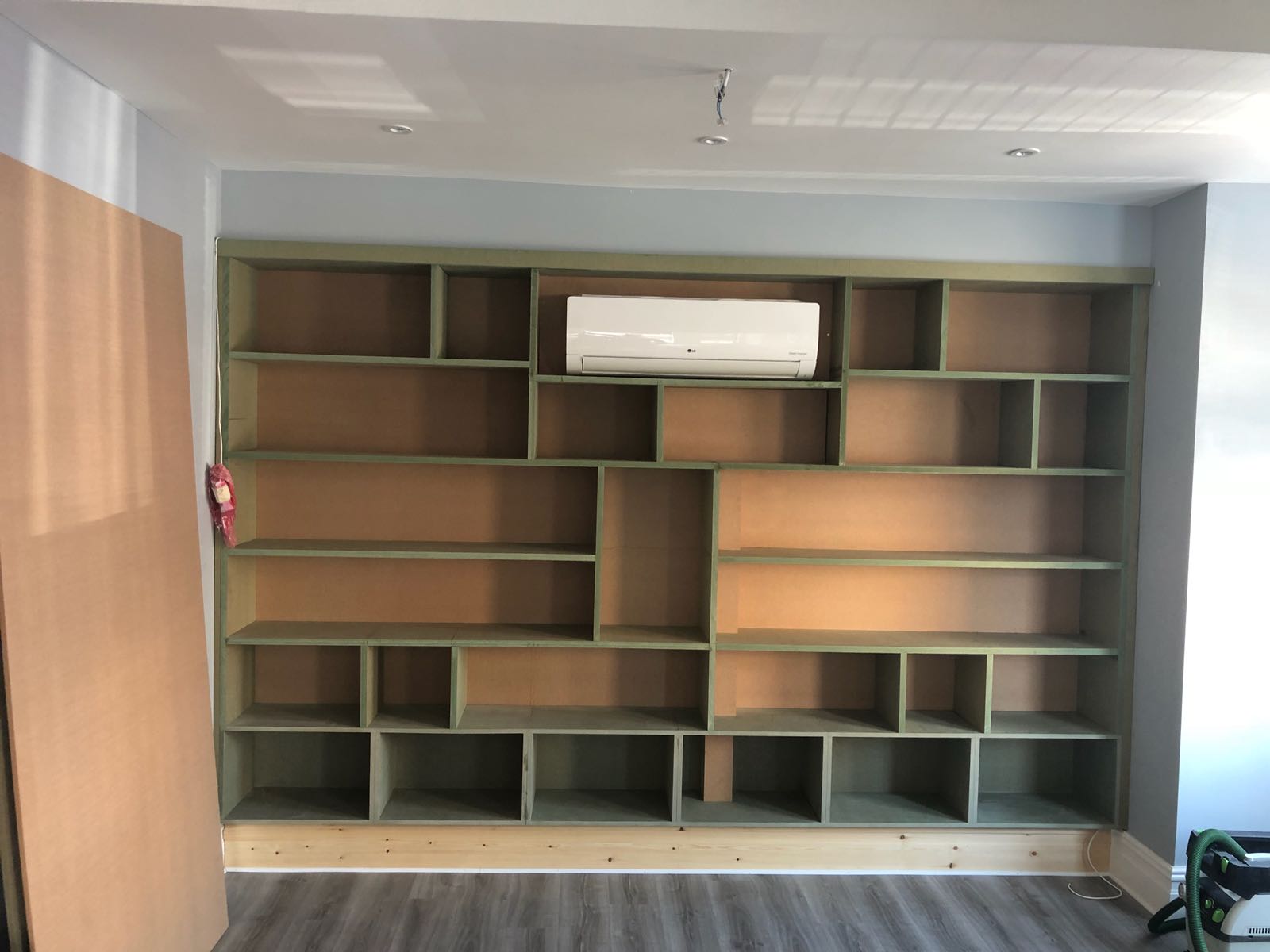 A room with a lot of shelves and a air conditioner