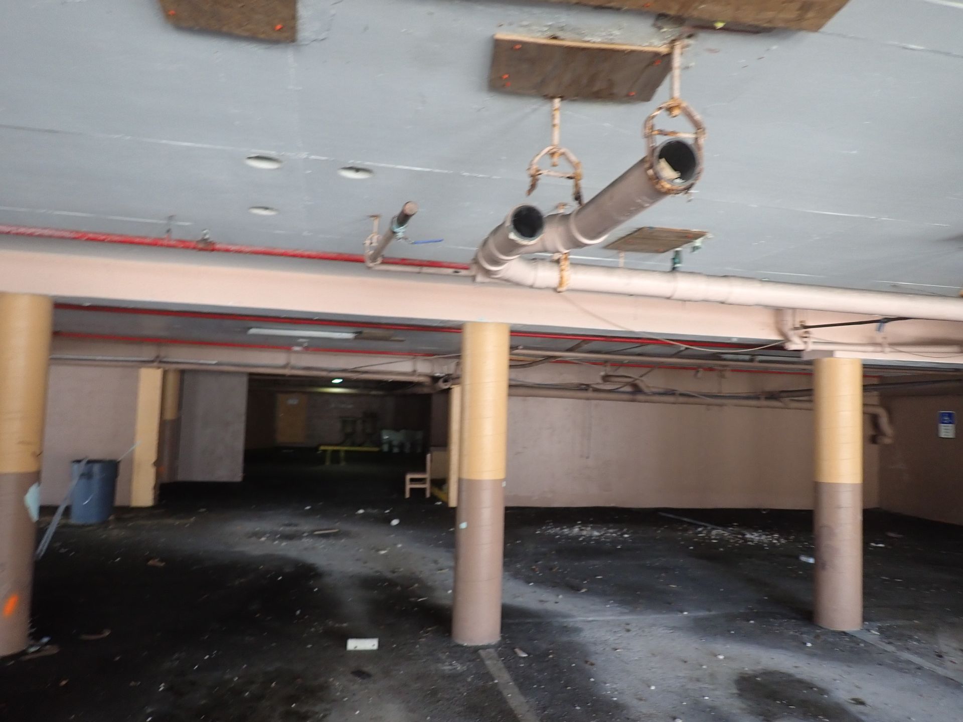 Parking garage ceiling with exposed piping and column supports, part of the structural scope on a Boca Raton recertification by M&P Consulting Engineers