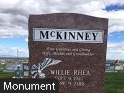 McKinney monument with Willie Rhea memorial plaque in a cemetery under cloudy sky