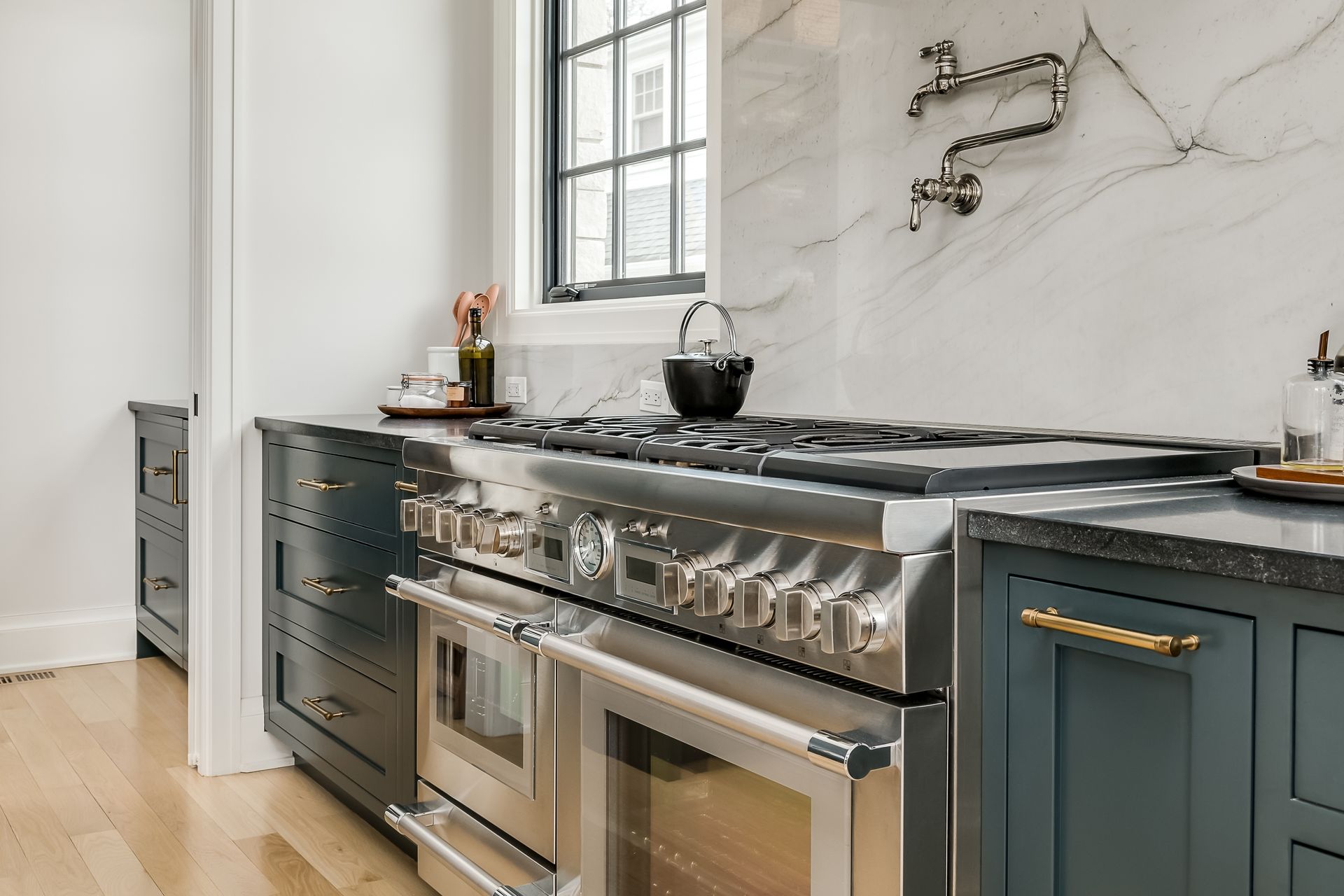 A kitchen with stainless steel appliances and blue cabinets.