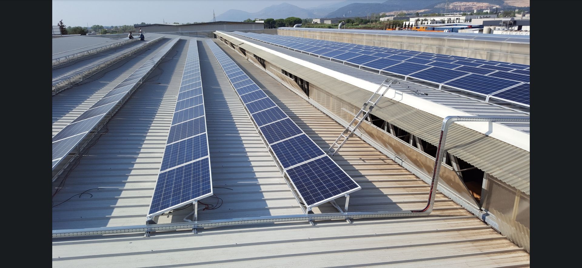 Pannelli solari installati su un tetto con file di pannelli blu sotto la luce del giorno