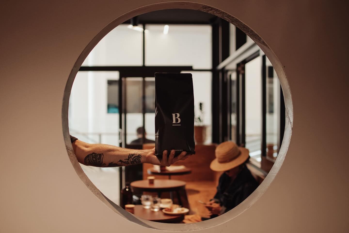 Hand Holding Coffee Bean In Mirror — Barber Bros & Co - Southport in Southport, QLD