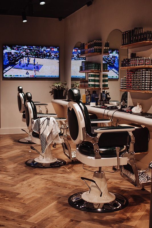 A Barber Shop With a Lot of Chairs and a Television on the Wall — Barber Bros & Co - Southport in Southport, QLD