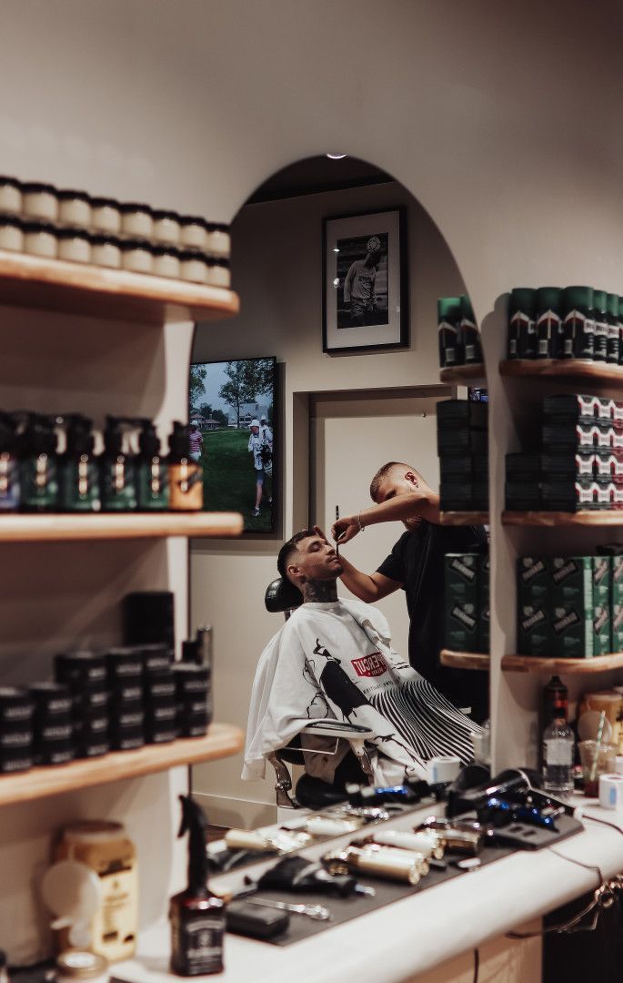 A Barber Shaving Another Mans Beard at Barber — Barber Bros & Co - Southport in Isle of Capri, QLD