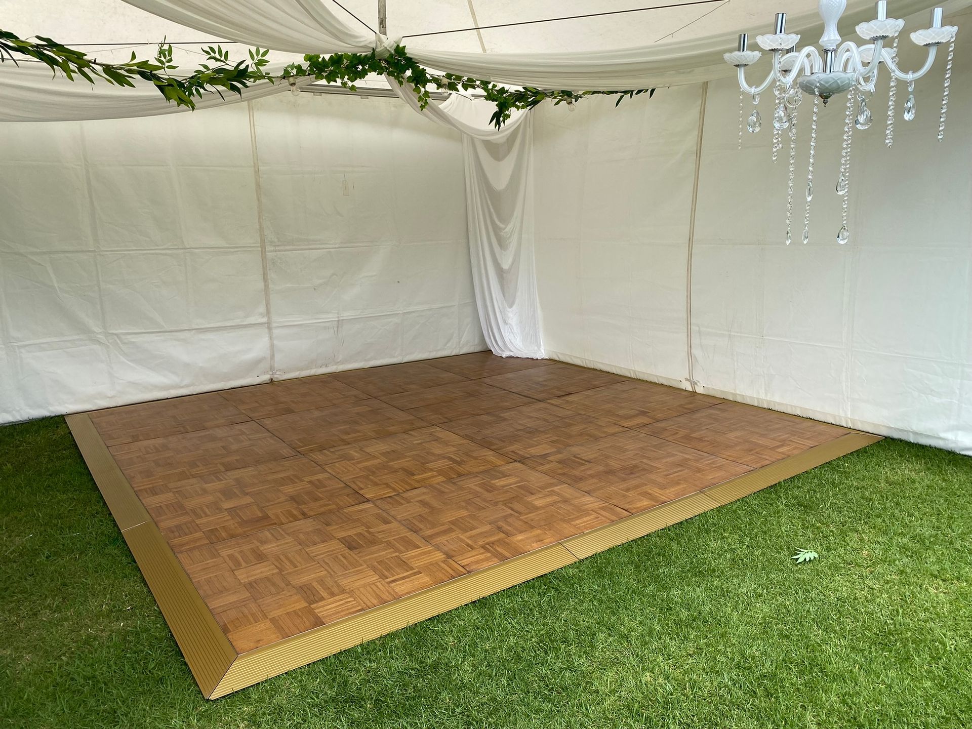 A Wooden Dance Floor In A Tent With A Chandelier Hanging From The Ceiling — Red Shed Hire In Wauchope, NSW