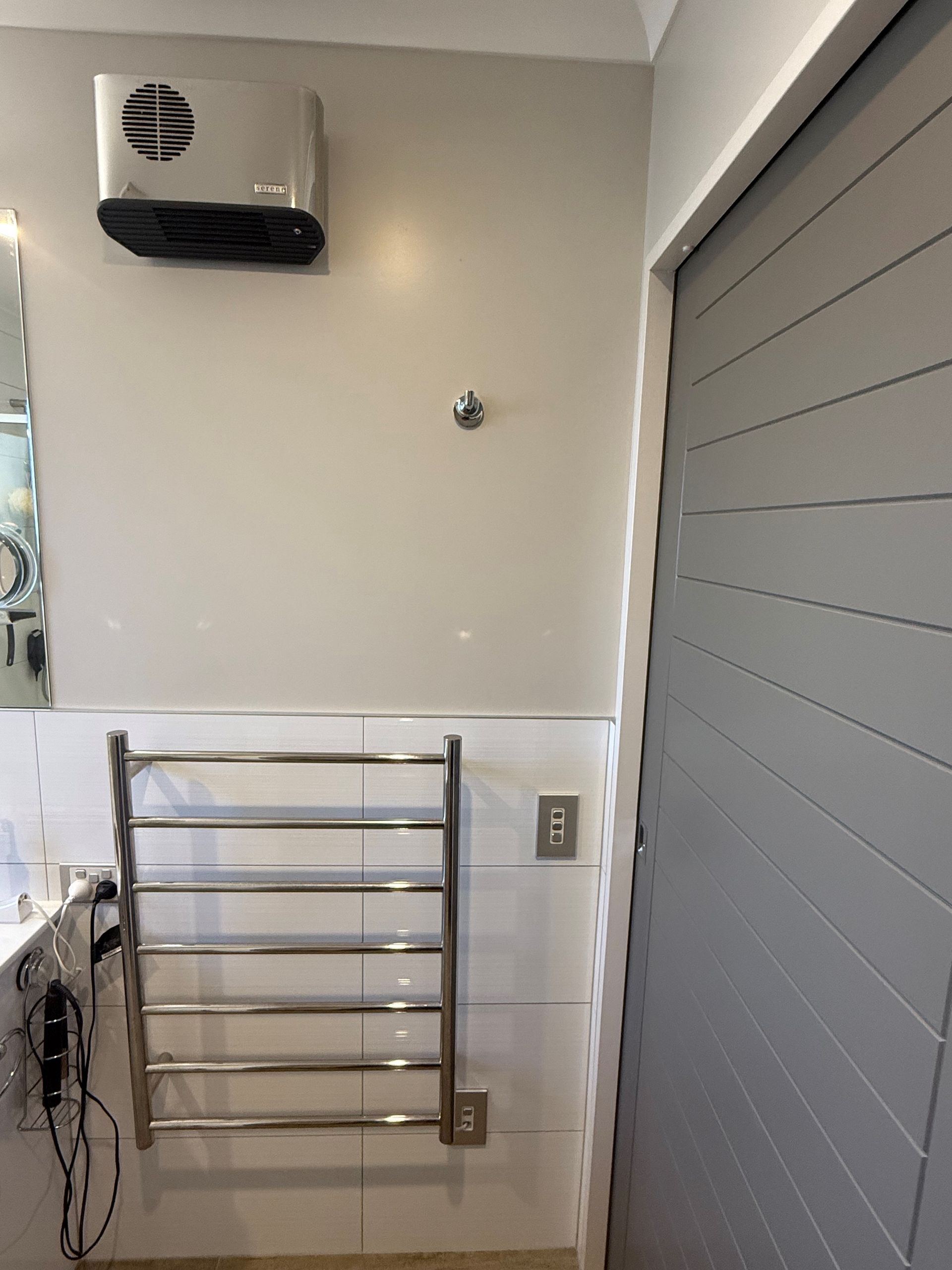 Spacious modern kitchen with stainless steel appliances, white cabinets, and hardwood floors.