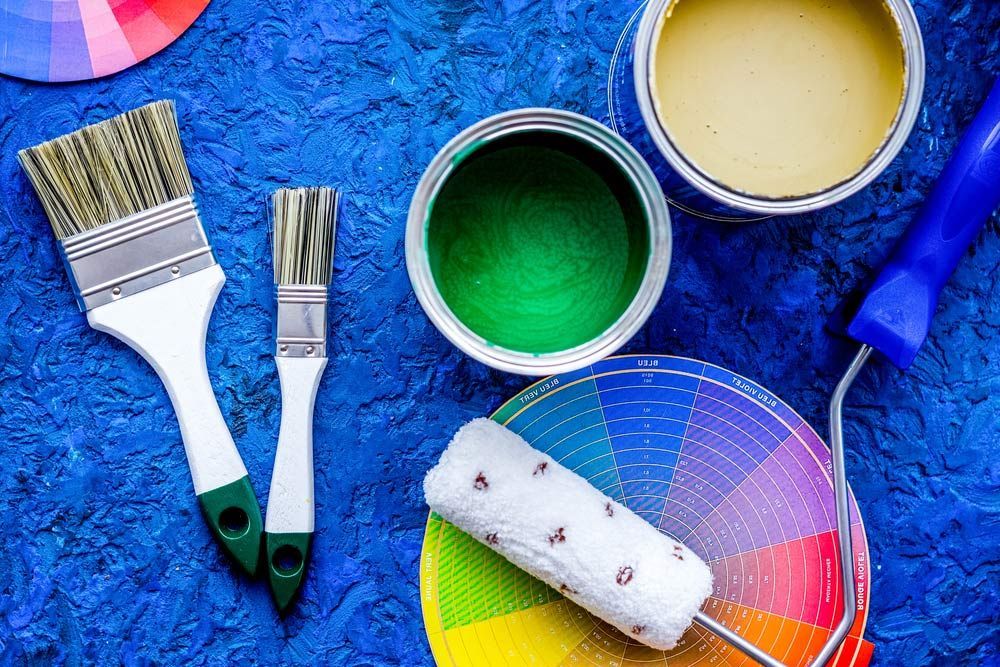 Two Cans Of Painting With Roller And Paintbrush — Paint & Decor in Birdsville, QLD