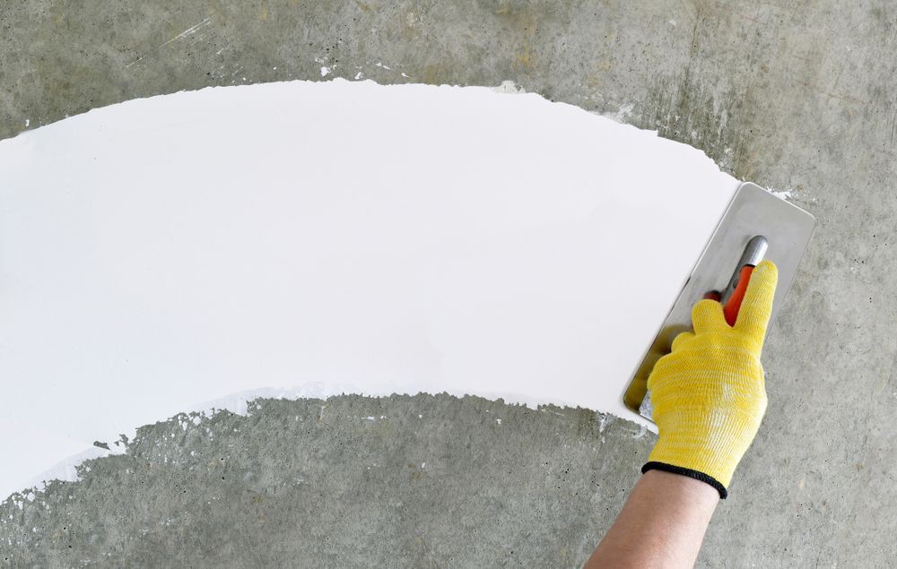 Painter Paints Office Wall With Roller Brush — Paint & Decor in Mount Isa City, QLD