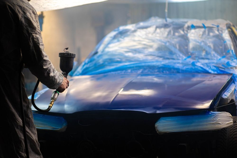 Worker Painting A Car In A Paint Booth — Paint & Decor in Mount Isa City, QLD