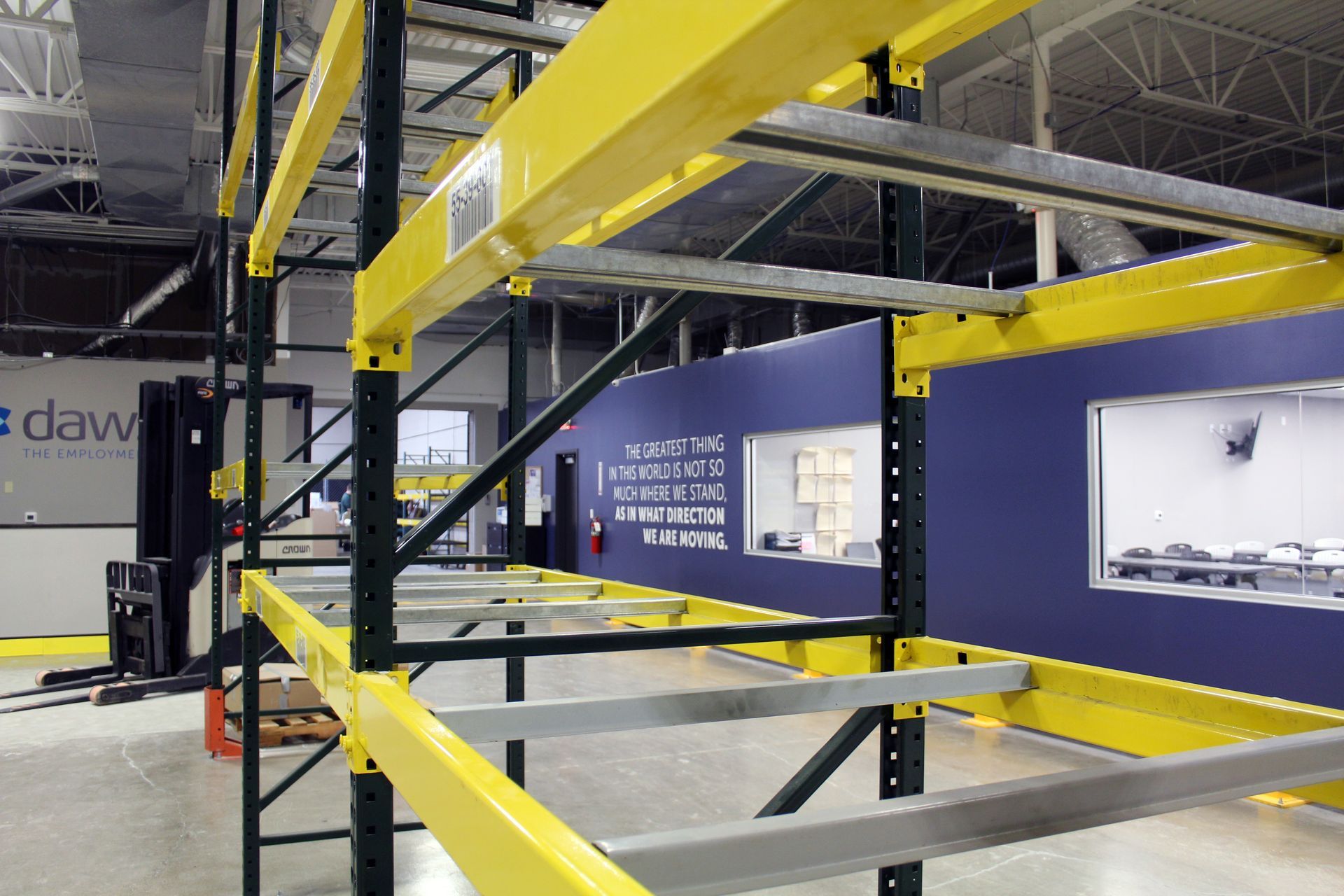A view of tall, yellow and black metal industrial shelving units in a warehouse setting.
