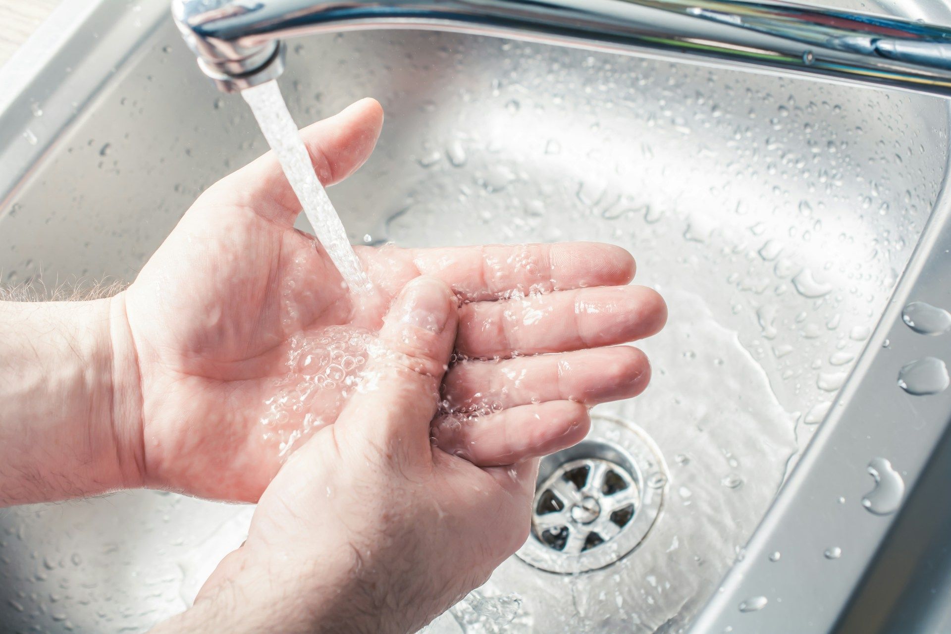 washing hands under the faucet