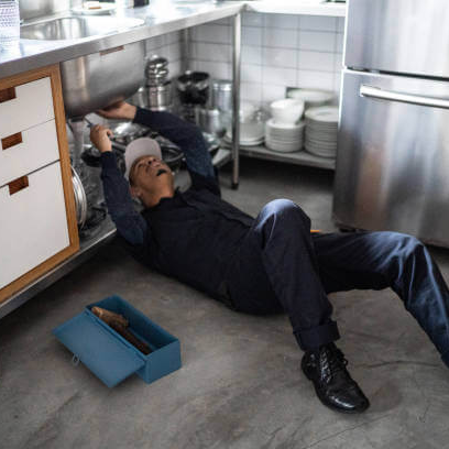 plumber working in kitchen