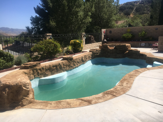 A large swimming pool surrounded by rocks and trees