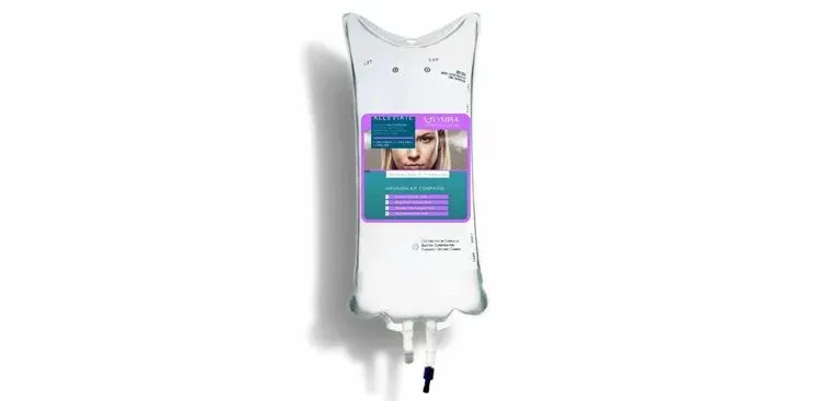 White wall-mounted soap dispenser with a purple label and handwashing graphic