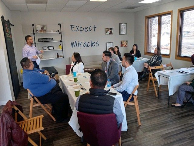 Small group meeting in a bright room, with “Expect Miracles” on the wall and people seated in a circle.