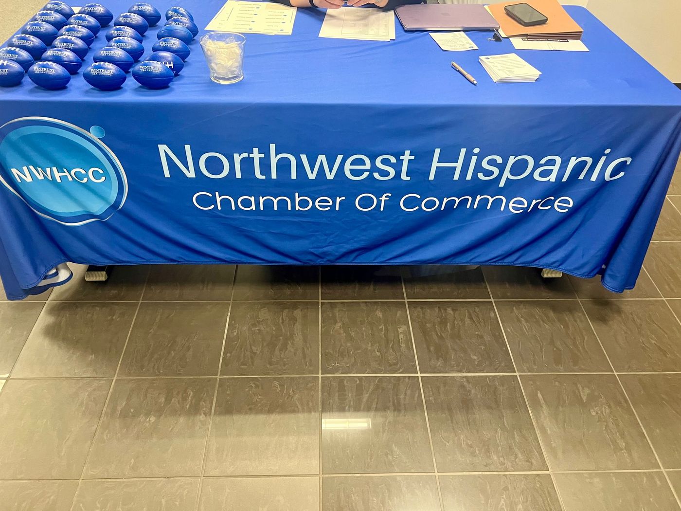 Northwest Hispanic Chamber of Commerce table with blue tablecloth and promotional items