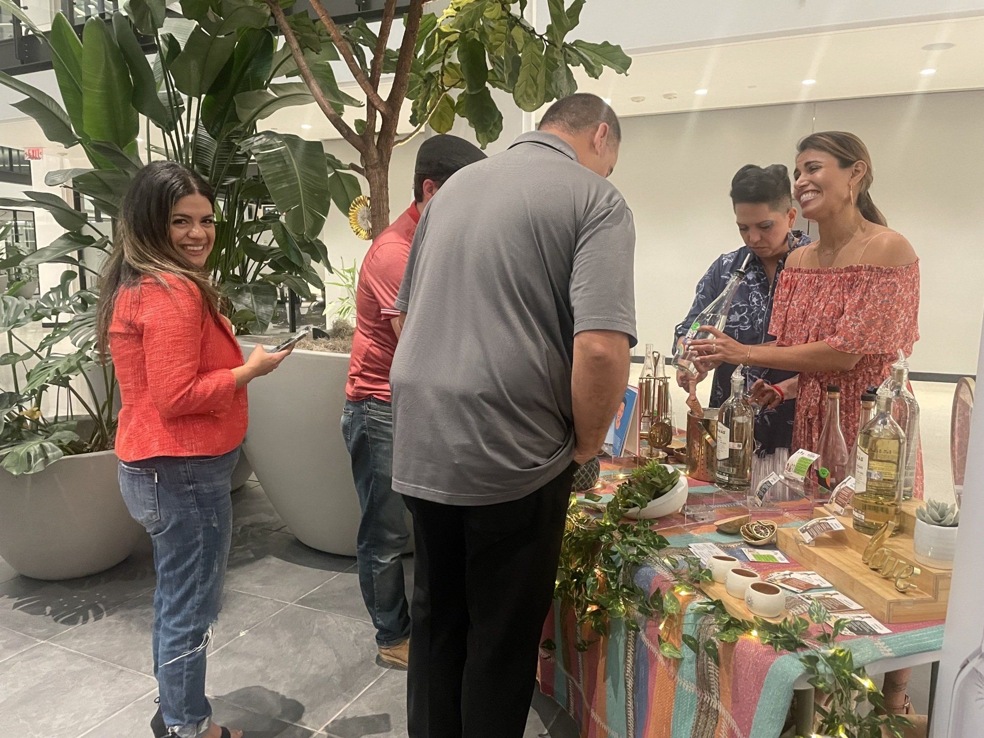 People browsing a craft stall outdoors, with colorful handmade items displayed on a table.