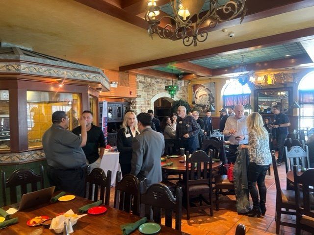 People chatting around tables in a cozy pub with warm lighting and stone walls