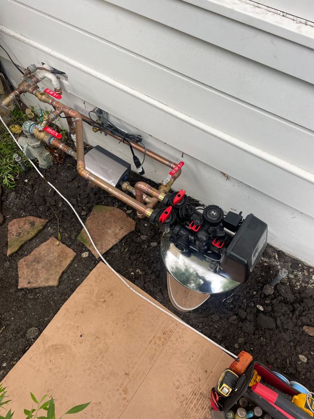 A machine is sitting on the ground next to a house.