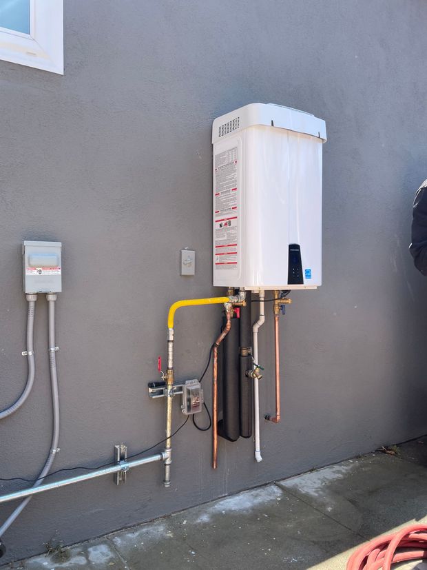 A white water heater is attached to the side of a building