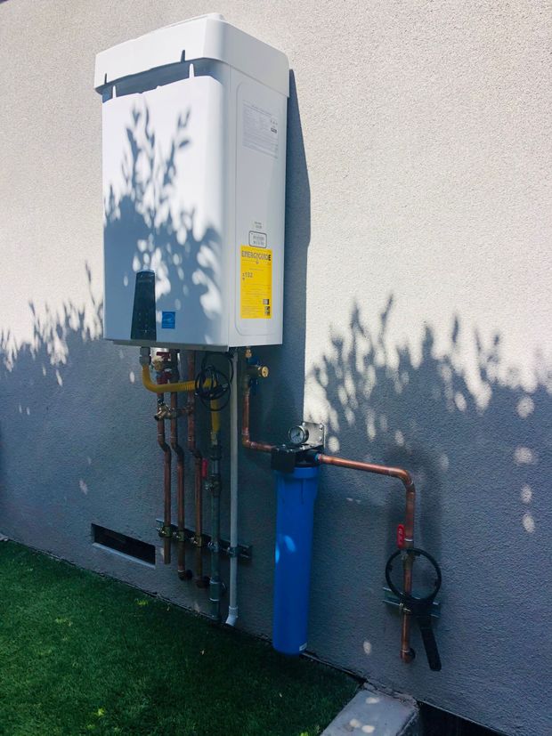 A water heater is attached to the side of a building.