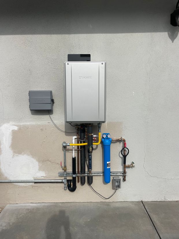 A water heater is mounted to the side of a building