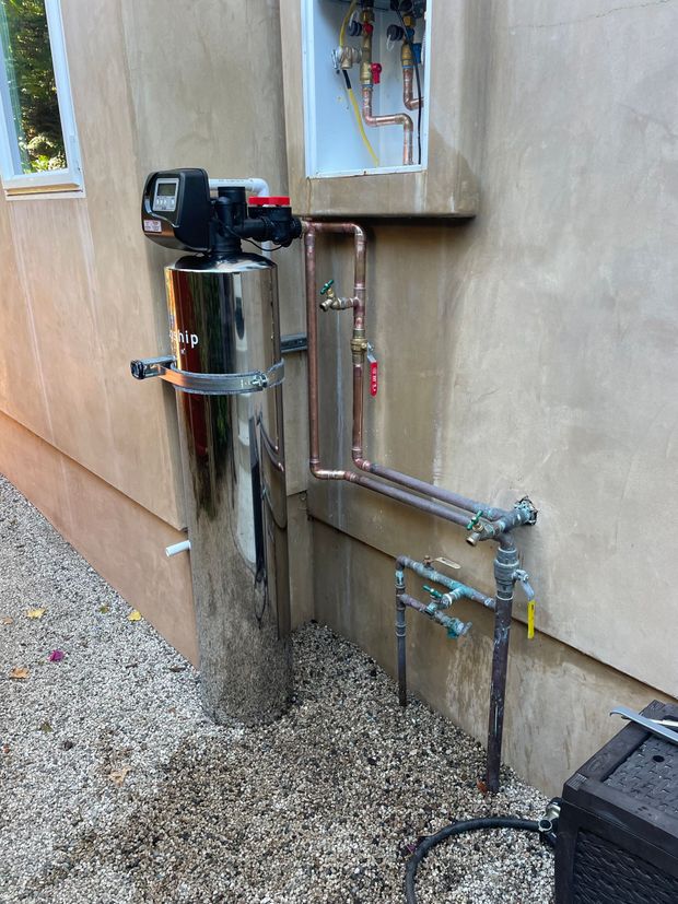 A water filter is attached to the side of a building.