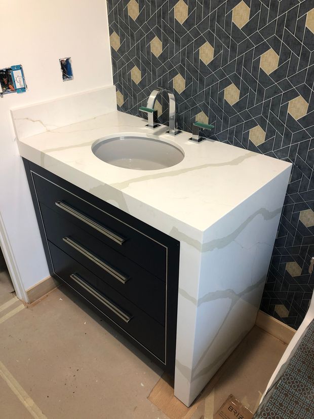 A bathroom vanity with a sink and drawers underneath it.