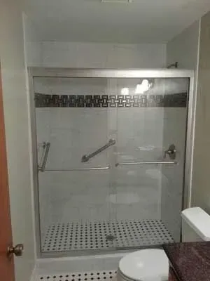 A bathroom with a walk in shower , toilet and sink.