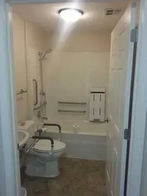 A bathroom with a toilet , sink , tub and shower.