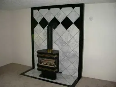 A fireplace with black and white tiles and a wood stove