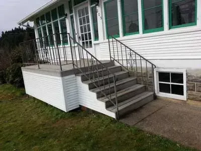 There are stairs leading up to the front of a house.