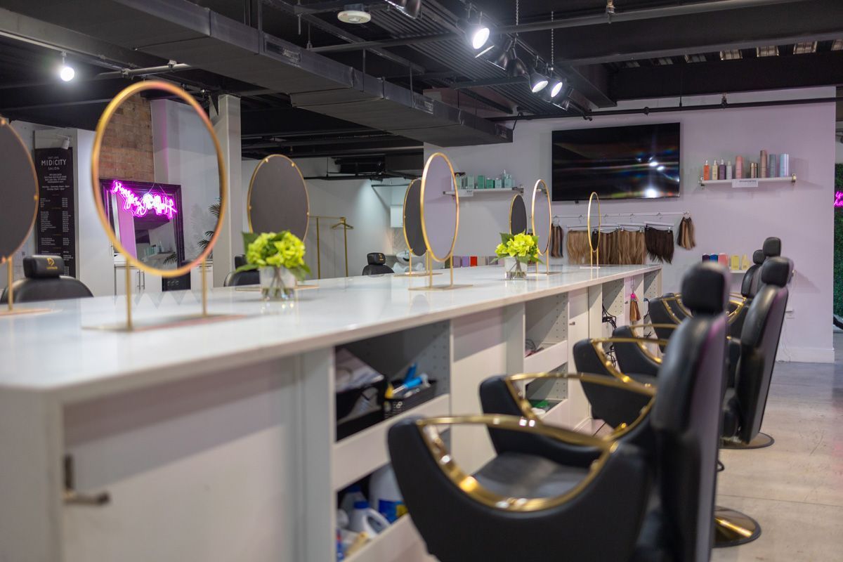 Modern salon interior with styling chairs, mirrors, and a long white counter under bright lights