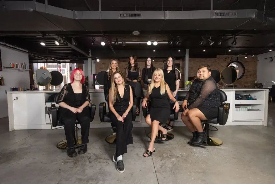 Five people seated in a studio, facing the camera in a dim industrial-style room