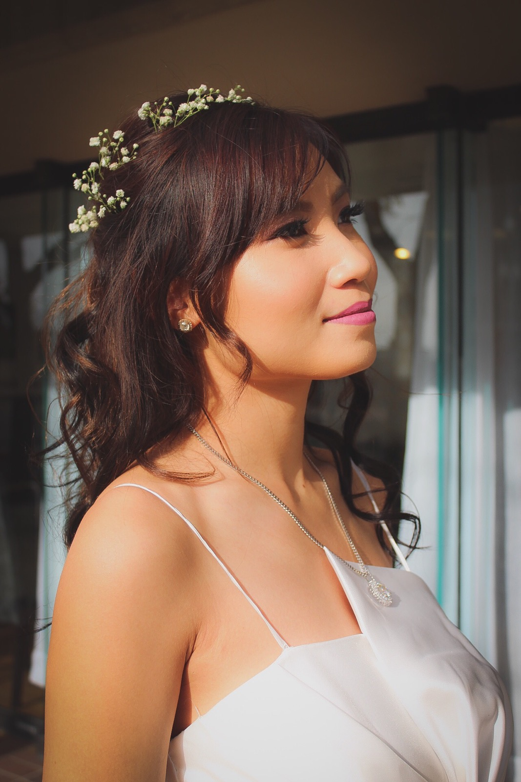Woman with long highlighted hair in a salon, shown from behind.