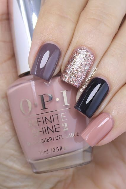 Hand holding OPI nail polish bottle beside mauve, glitter, and dark blue manicured nails
