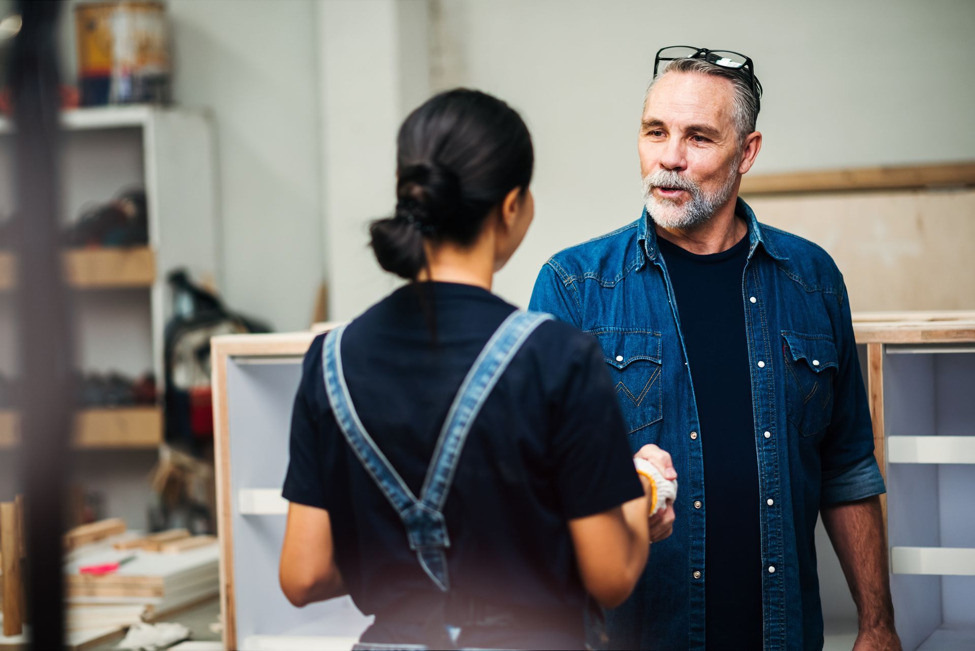 Barista handing a coffee cup to a customer; cafe setting, smiling.