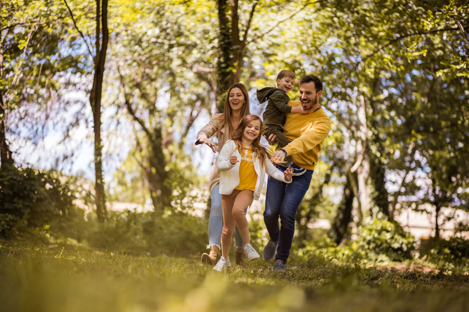 Mom, dad son and daughter enjoying the outdoors surrounded by trees