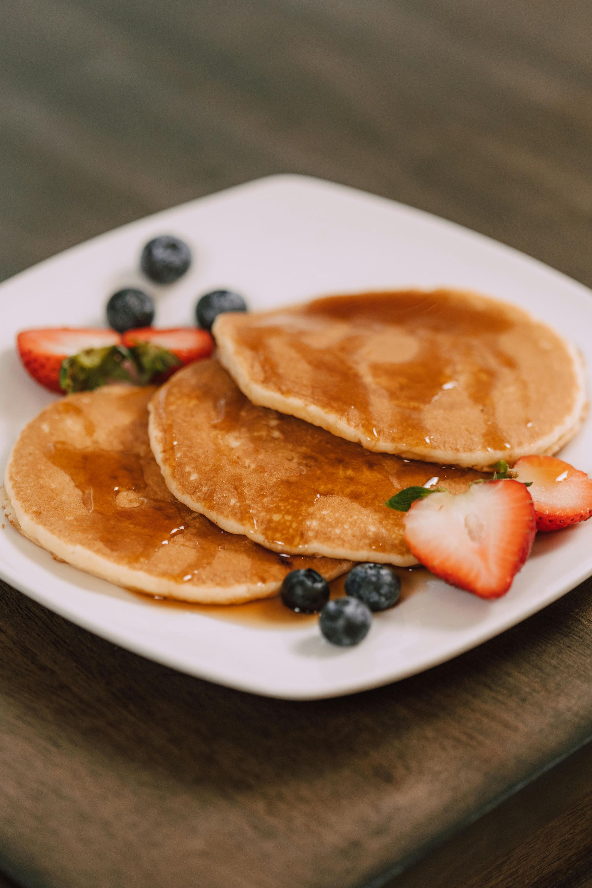 Pancakes and fruit on white plate