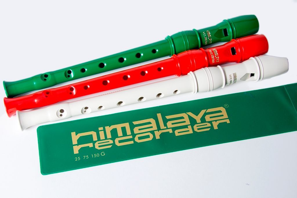 Tre flauti dolci colorati – verde, rosso e bianco – poggiano su una custodia verde a tema malese.