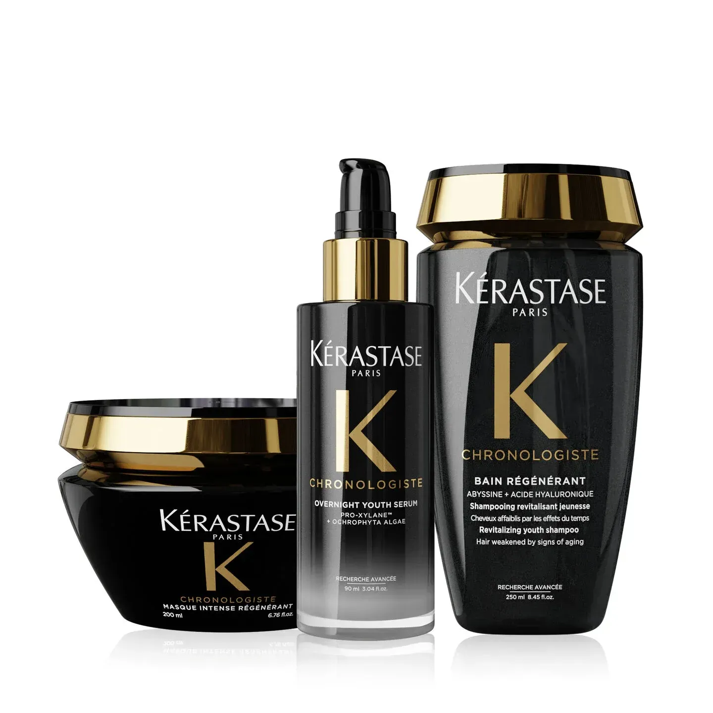 Three Kérastase haircare products in black and gold packaging on a white background