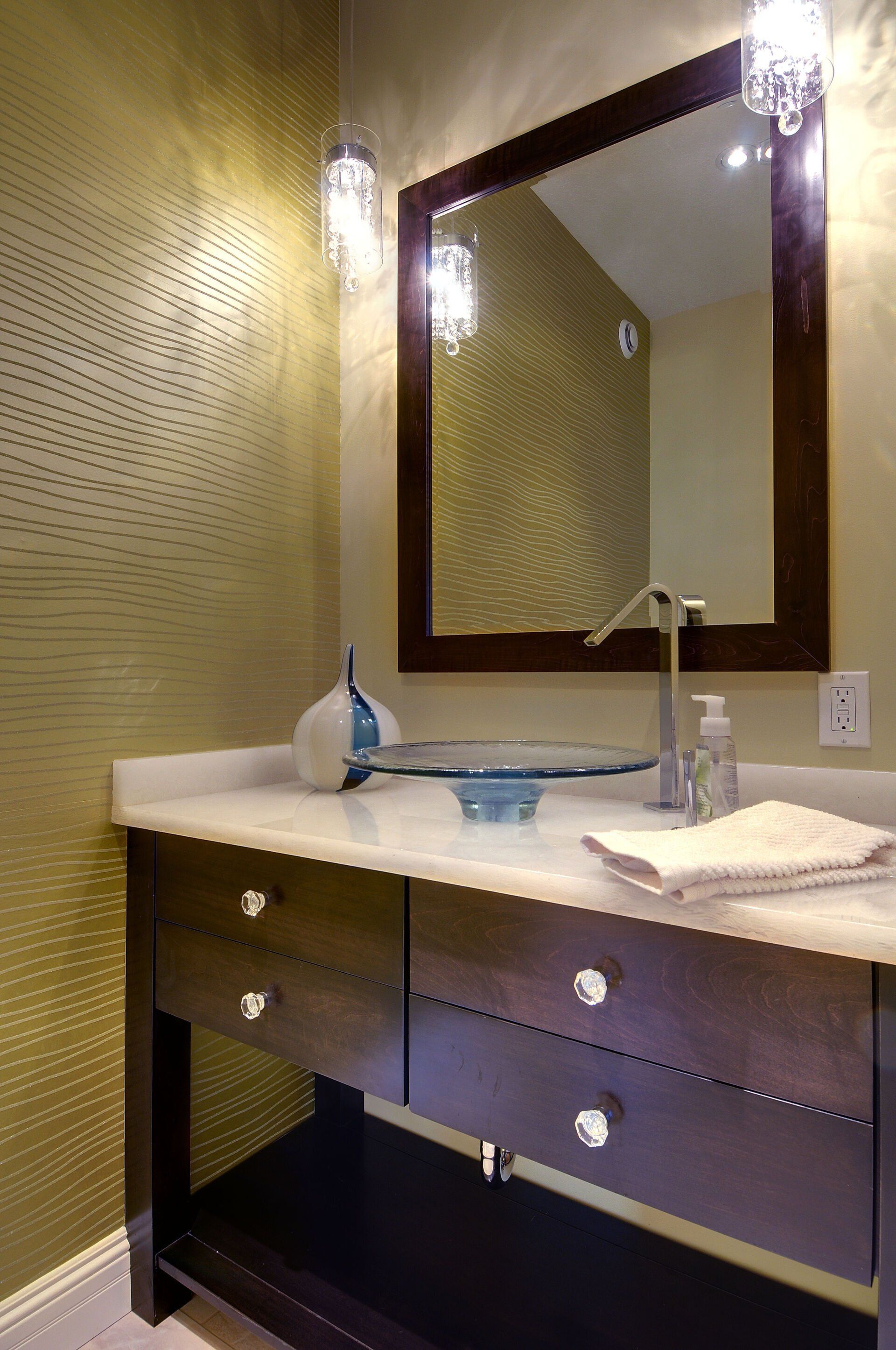 A bathroom with a sink , mirror and drawers