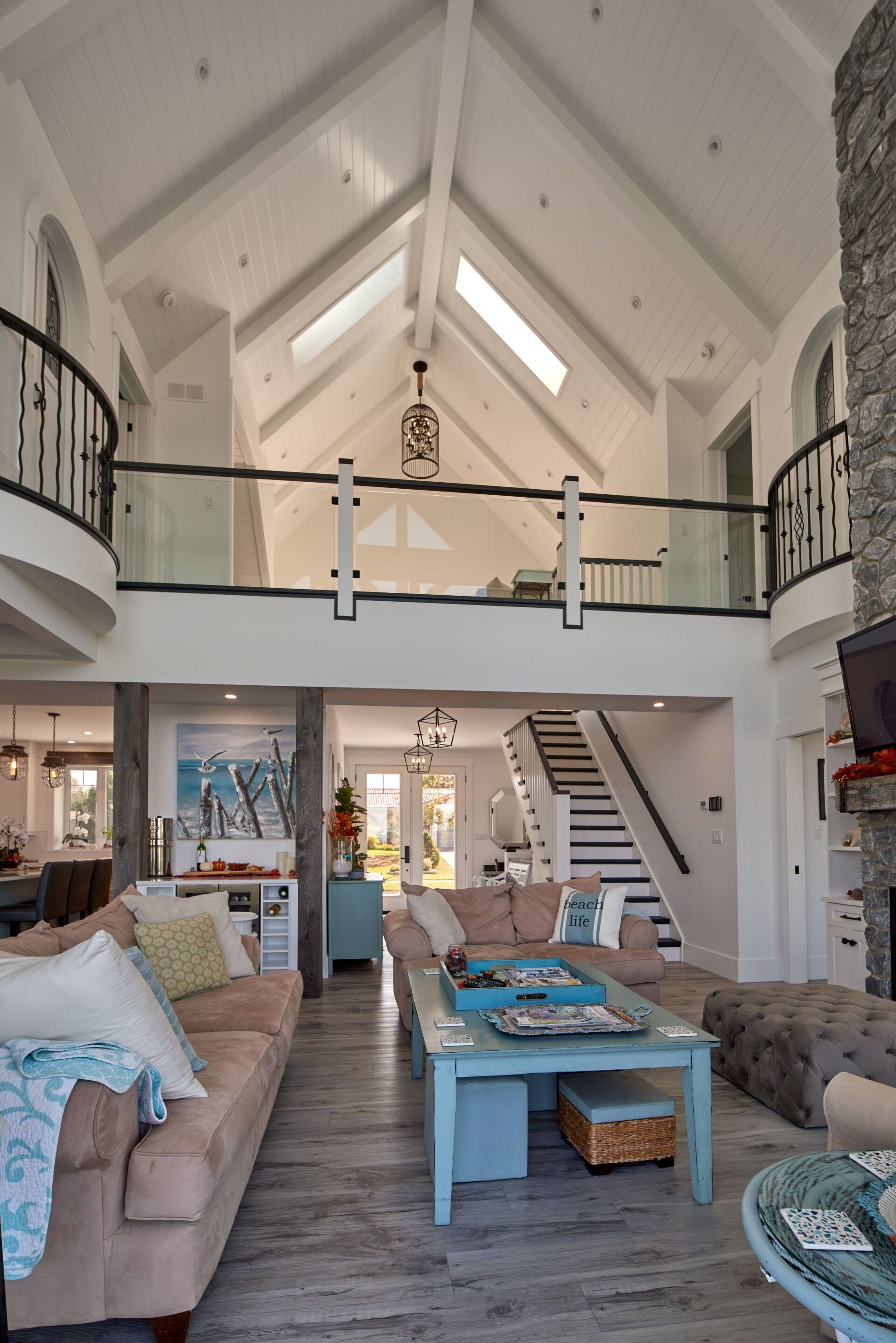 A living room with a vaulted ceiling and stairs