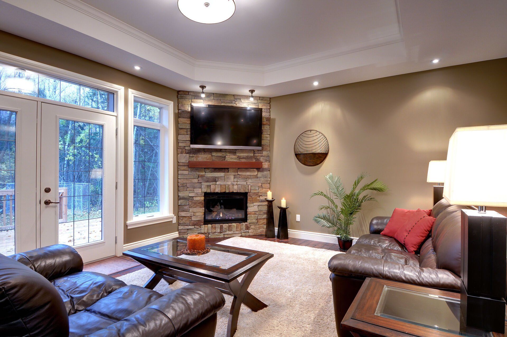 A living room with a couch , table , television and fireplace.