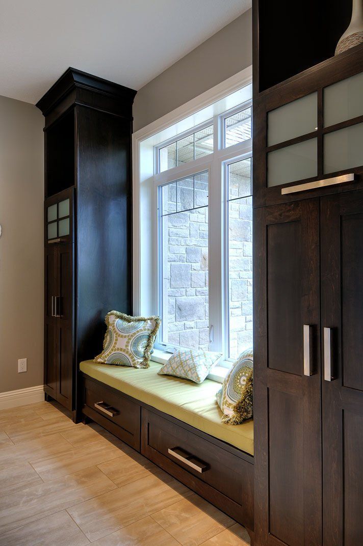 There is a window seat with drawers underneath it in a room.