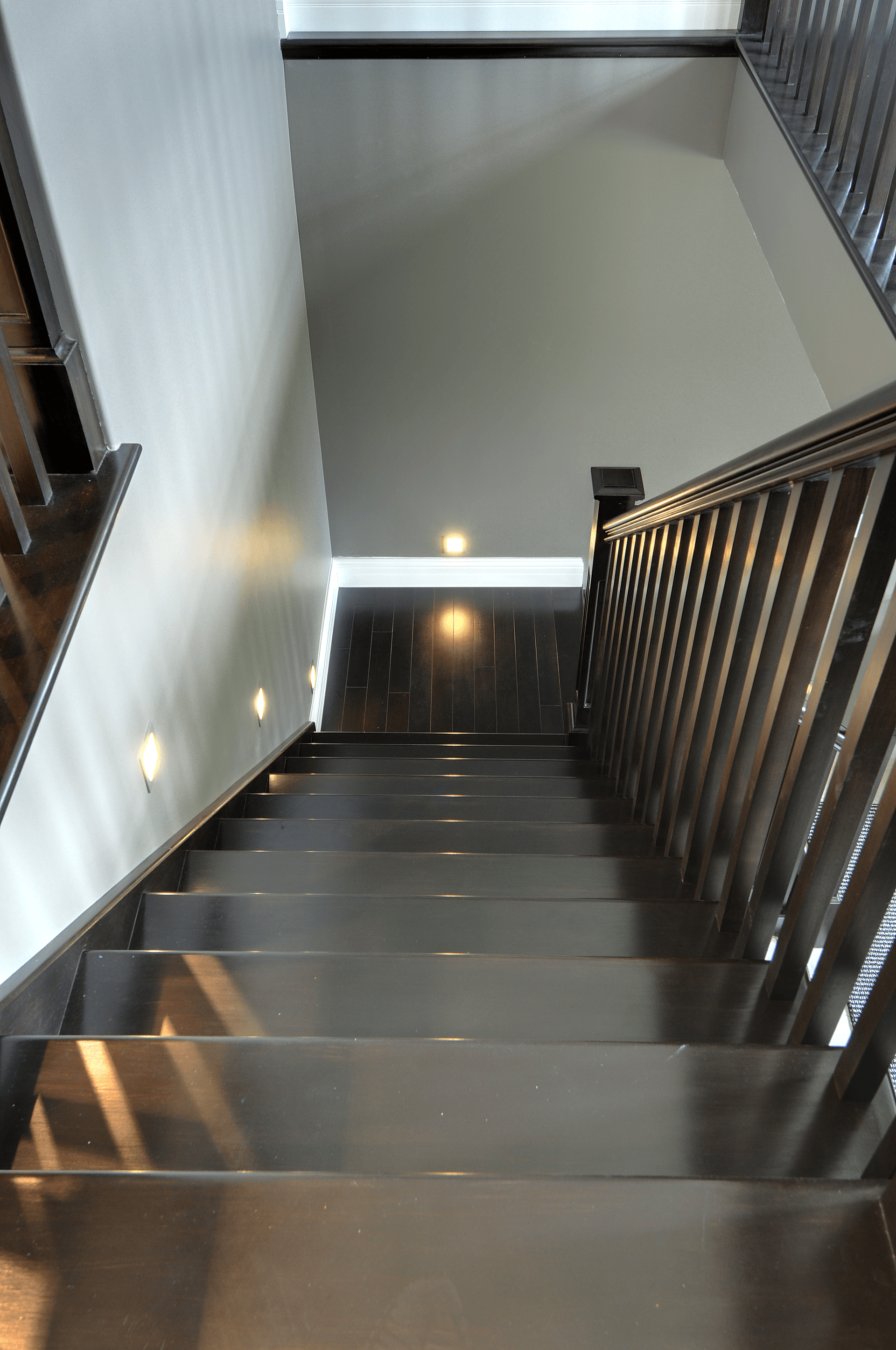 A staircase with stainless steel steps and a wooden railing