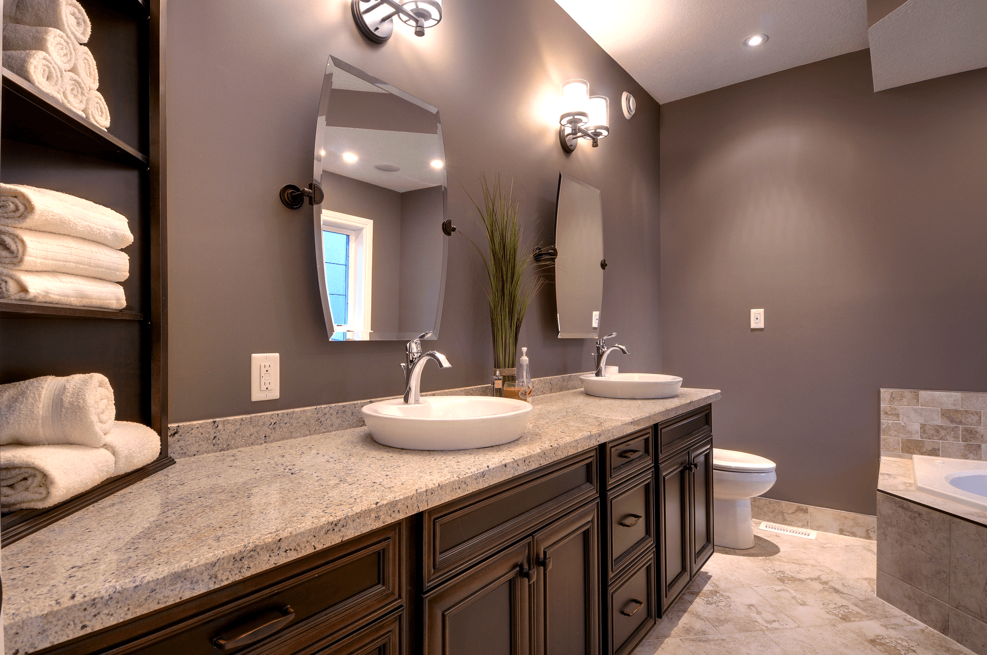 A bathroom with two sinks , a toilet , and a mirror.