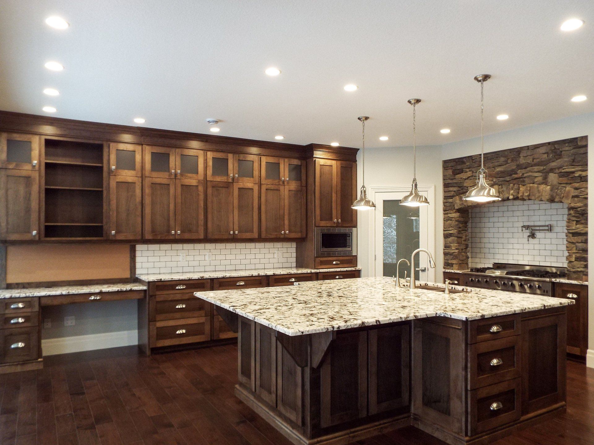 A kitchen with a large island and granite counter tops