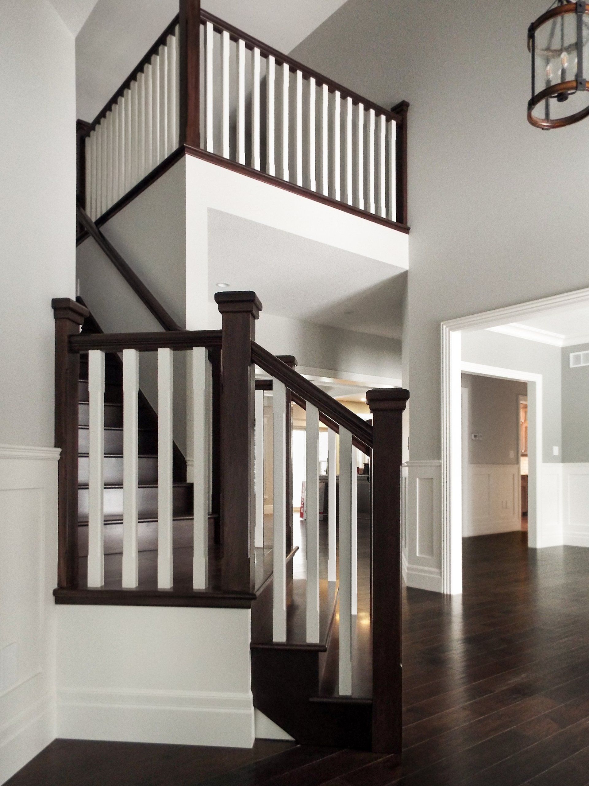 A staircase with a white railing leading to a second floor