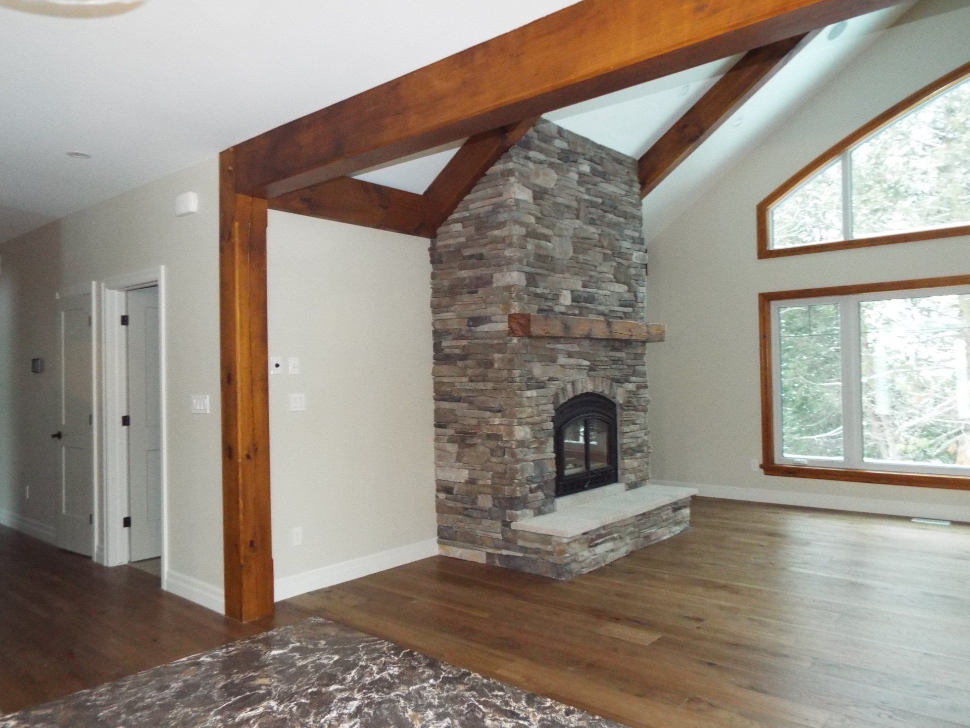 A living room with a stone fireplace and a vaulted ceiling